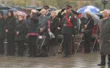 2012 Memorial Service - guests paying respects at memorial service in the rain with umbrellas (6)
